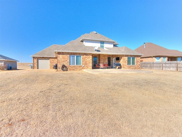 view of front of property featuring a garage, a patio area, and a front lawn