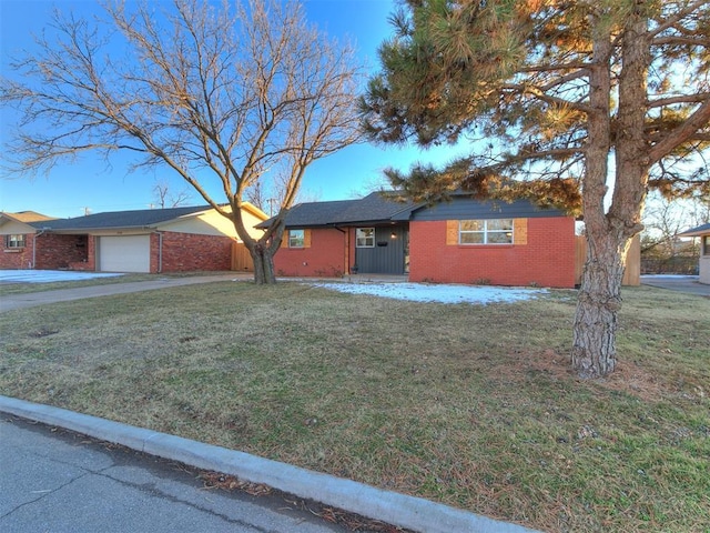 ranch-style home featuring a garage and a front lawn