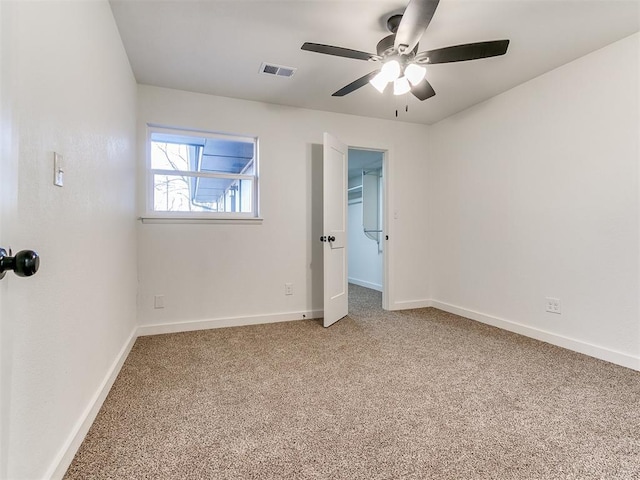 empty room featuring carpet floors and ceiling fan