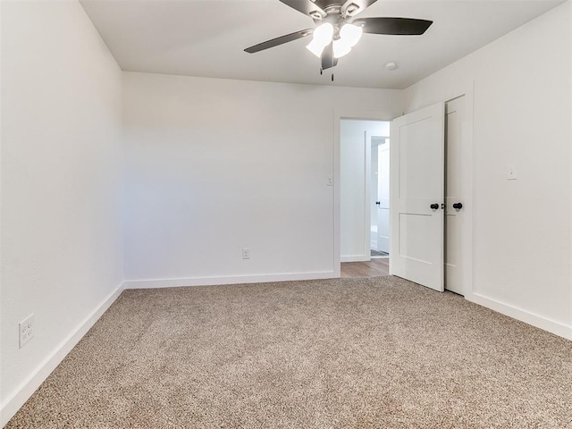 carpeted spare room with ceiling fan