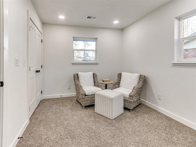 living area with a healthy amount of sunlight and light colored carpet