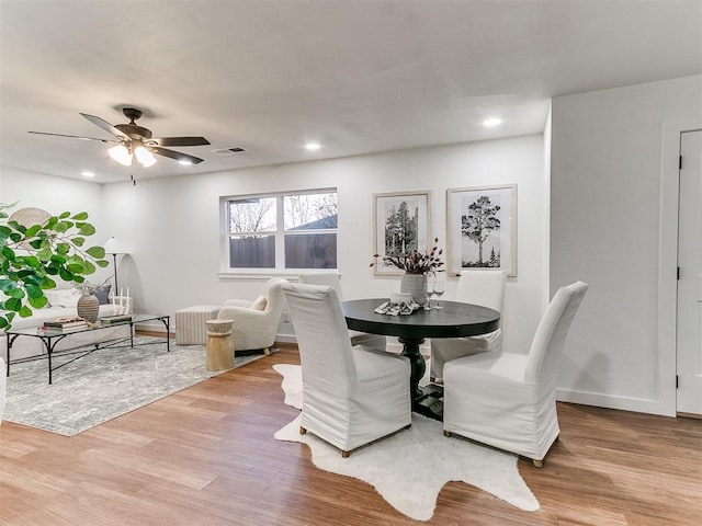 dining area with ceiling fan and light hardwood / wood-style floors