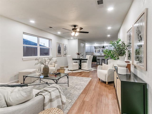 living room featuring ceiling fan, radiator, and light wood-type flooring