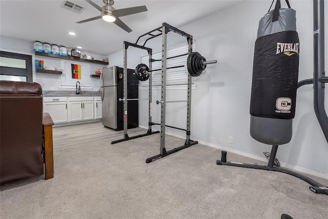 workout area featuring ceiling fan, light colored carpet, and sink