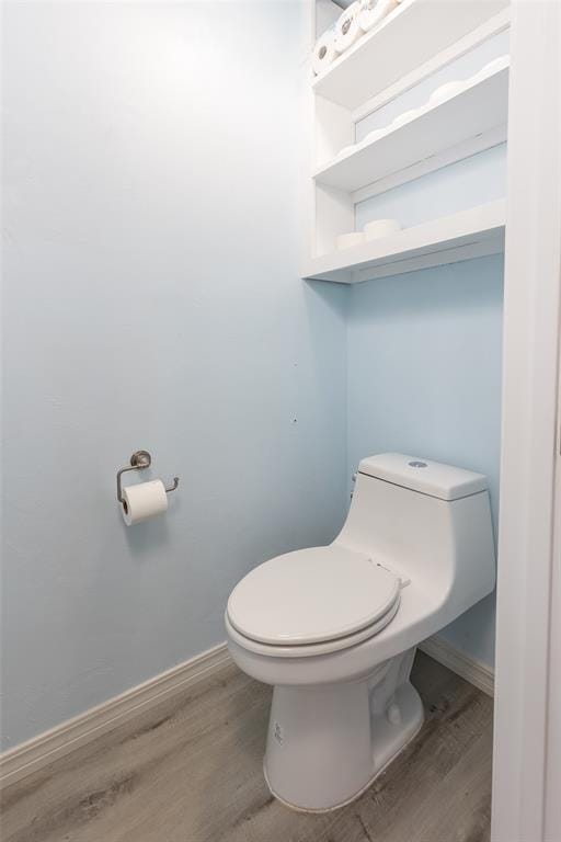 bathroom featuring wood-type flooring and toilet