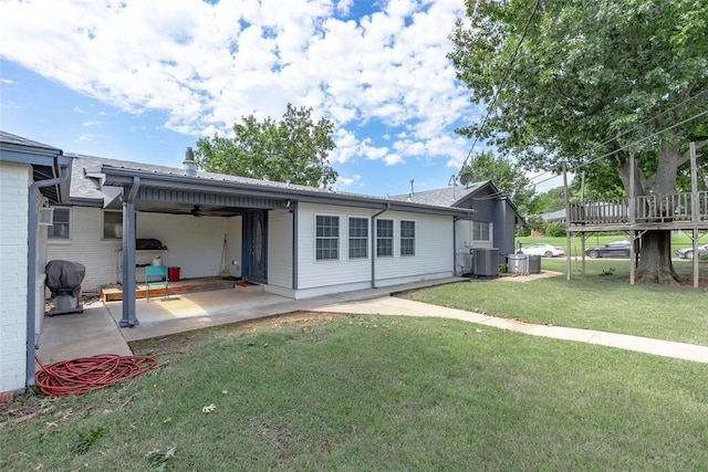 rear view of property with a wooden deck, a patio area, a lawn, and ceiling fan