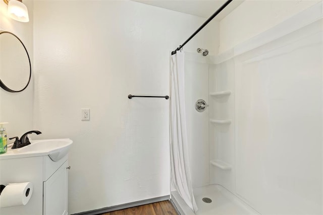 bathroom with a shower with shower curtain, hardwood / wood-style flooring, and vanity