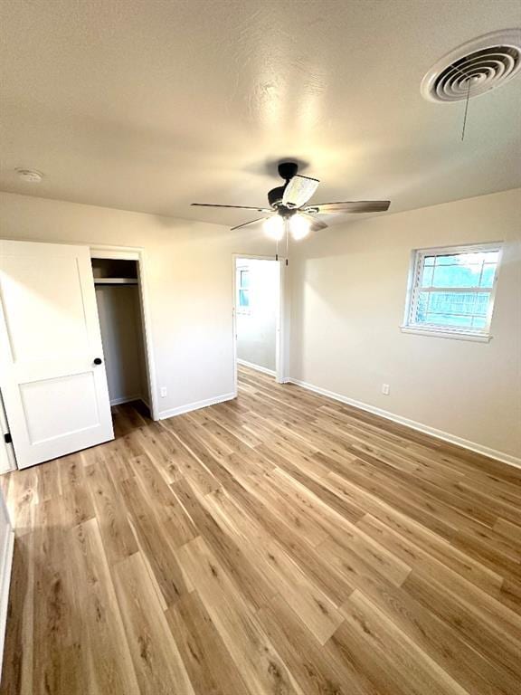 unfurnished bedroom with ceiling fan and light wood-type flooring