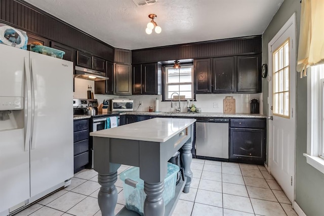 1815 N Bell Ave, Shawnee, OK 74804 - kitchen with appliances with stainless steel finishes, a sink, under cabinet range hood, light countertops, and light tile patterned floors