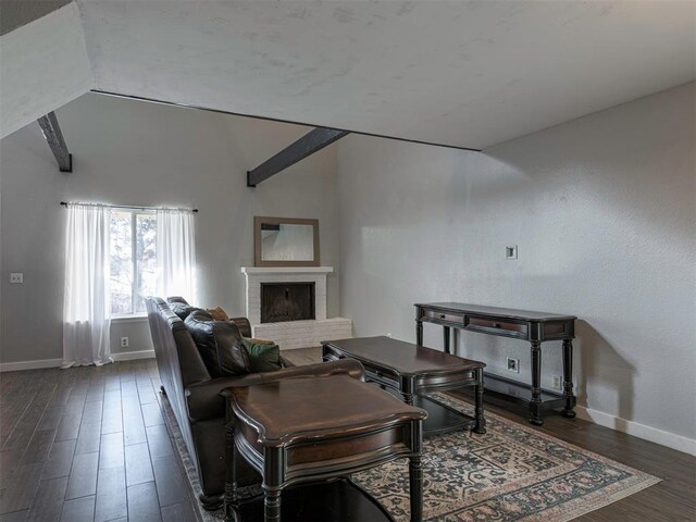 living room featuring lofted ceiling, a brick fireplace, and dark wood-type flooring