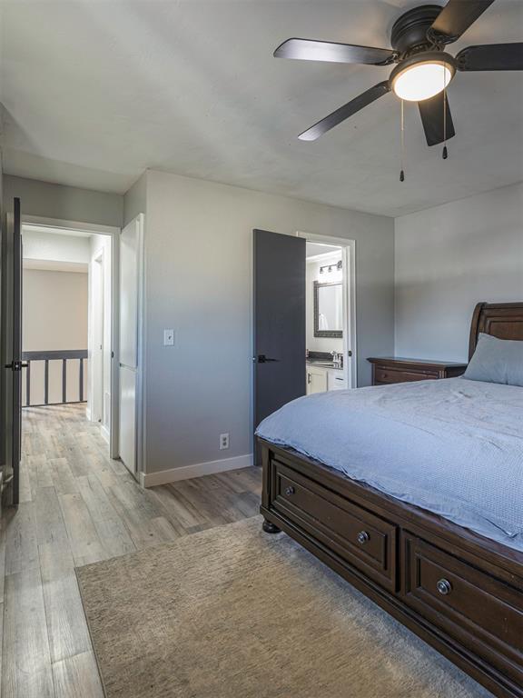 bedroom featuring ensuite bath, ceiling fan, and light hardwood / wood-style flooring