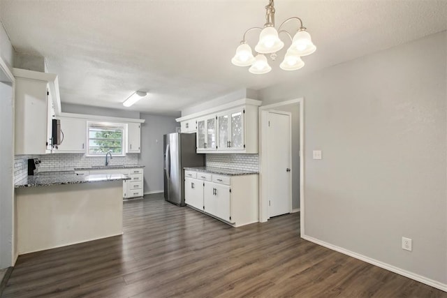 kitchen with decorative light fixtures, tasteful backsplash, a notable chandelier, stainless steel appliances, and white cabinets