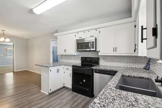 kitchen with white cabinets, a notable chandelier, light stone counters, and stainless steel appliances