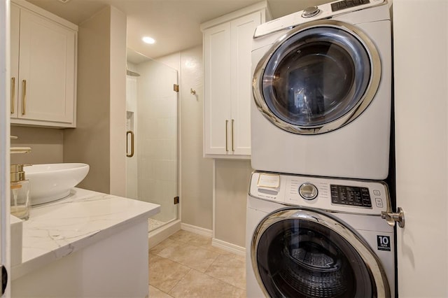 laundry room with sink, stacked washing maching and dryer, and light tile patterned flooring