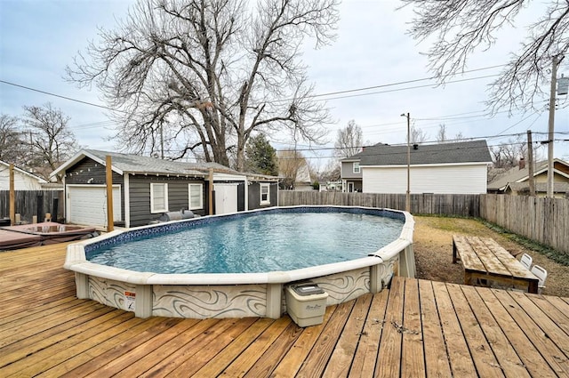 view of swimming pool featuring an outbuilding, a wooden deck, and a garage