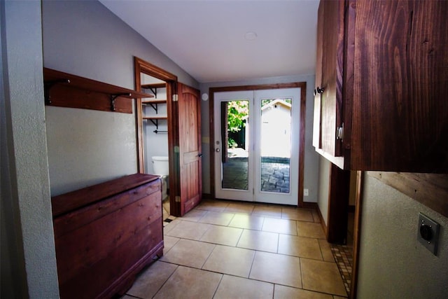 entryway featuring light tile patterned floors and vaulted ceiling