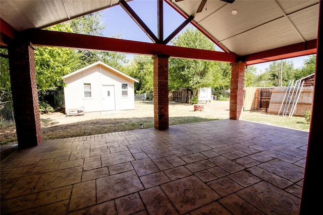 view of patio with ceiling fan and a shed