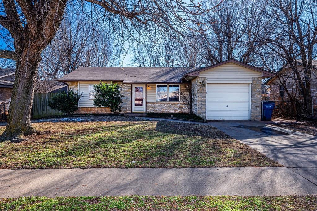 single story home with a front yard and a garage