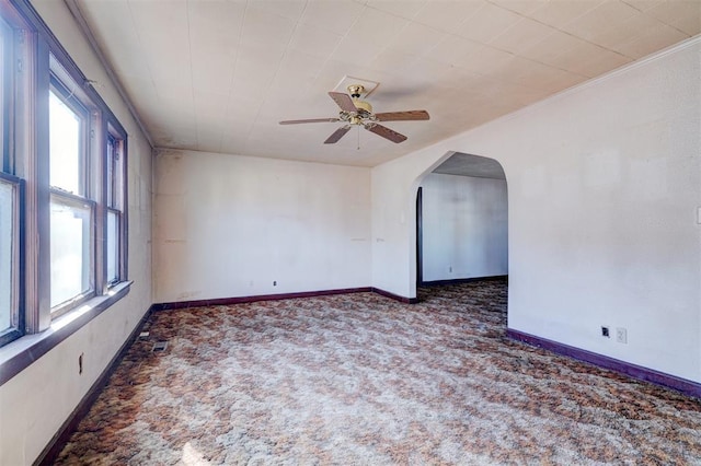 unfurnished room featuring ceiling fan and dark colored carpet