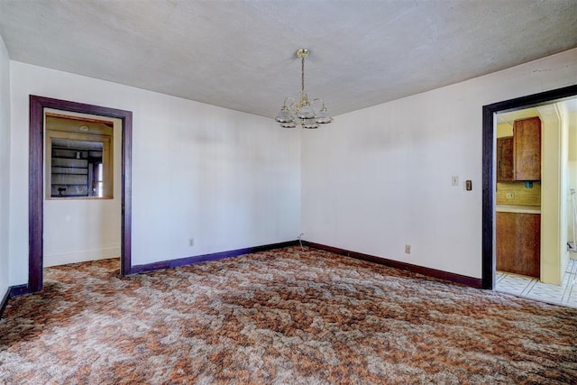 spare room with carpet and an inviting chandelier