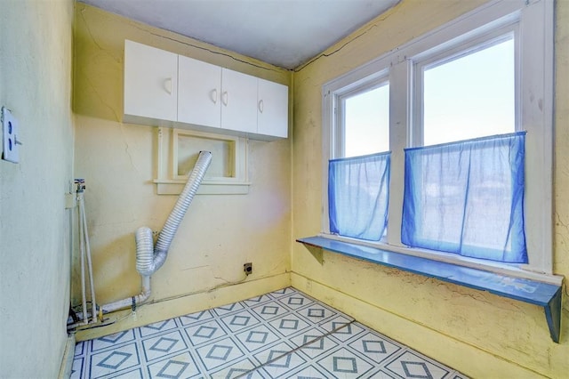 laundry area with electric dryer hookup and cabinets