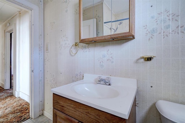 bathroom featuring tile patterned floors, tile walls, toilet, and vanity