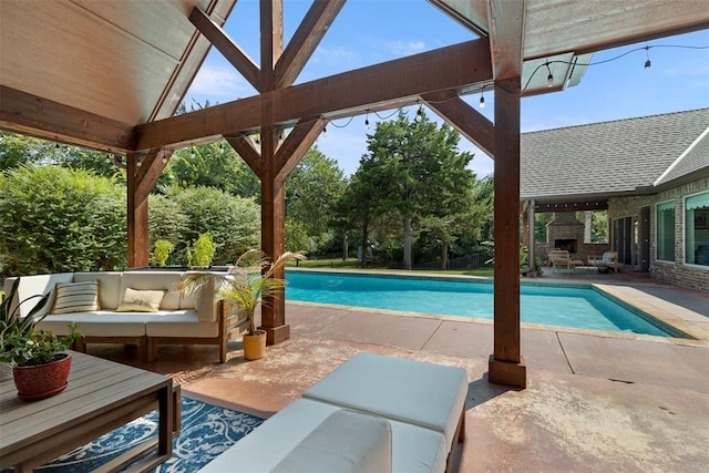 view of swimming pool with a patio and an outdoor living space with a fireplace