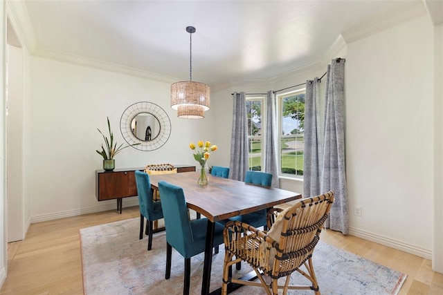 dining area with light hardwood / wood-style flooring and ornamental molding