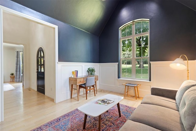 living room with vaulted ceiling and light wood-type flooring