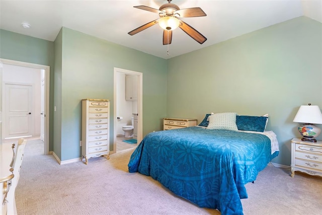 carpeted bedroom with ensuite bathroom and ceiling fan