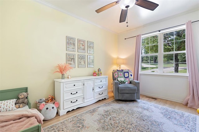 bedroom featuring crown molding, ceiling fan, and light wood-type flooring