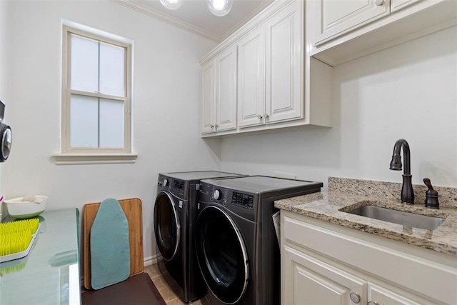 clothes washing area with cabinets, washing machine and dryer, sink, and ornamental molding