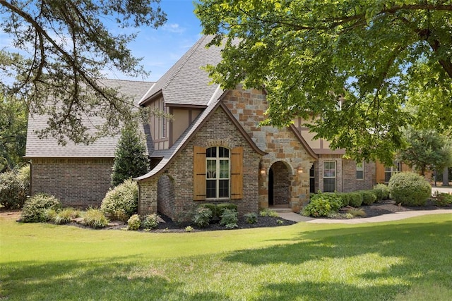 tudor home with a front lawn