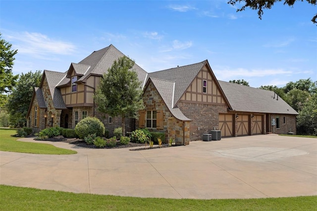 tudor home with cooling unit and a garage