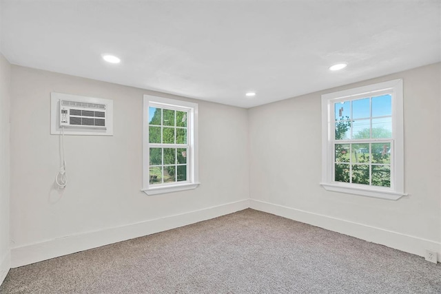 empty room featuring a wall unit AC and carpet floors