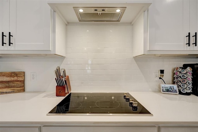 kitchen with black electric cooktop, tasteful backsplash, and white cabinets