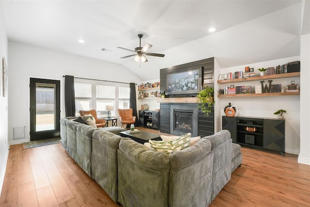 living room with ceiling fan, lofted ceiling, and light hardwood / wood-style floors