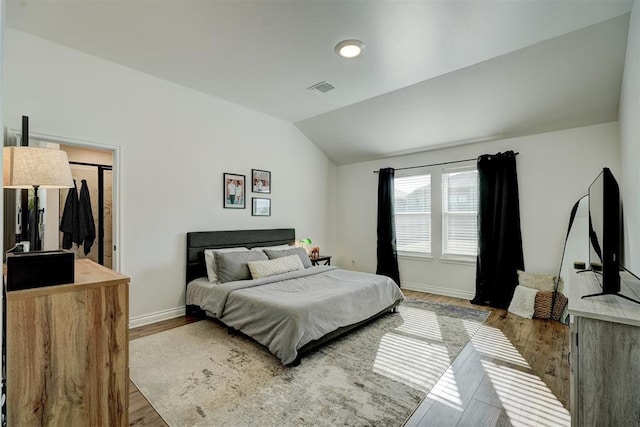 bedroom with hardwood / wood-style flooring and vaulted ceiling