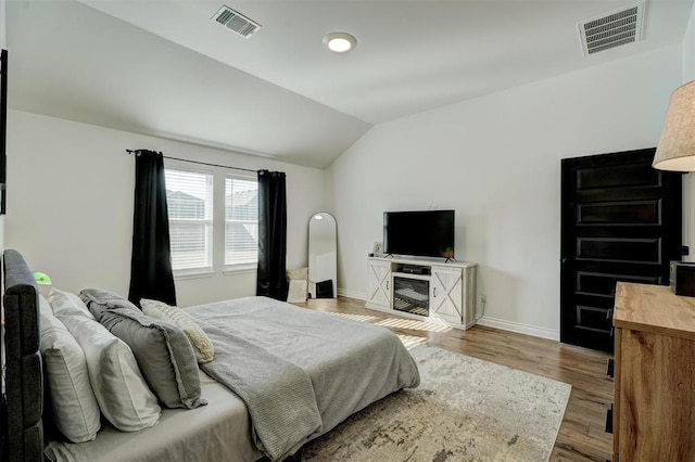 bedroom with vaulted ceiling and wood-type flooring