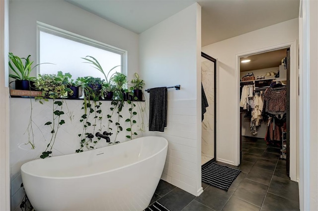 bathroom featuring separate shower and tub, tile patterned flooring, and tile walls