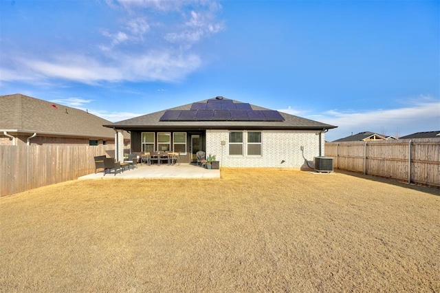 back of house featuring cooling unit, a patio area, and solar panels