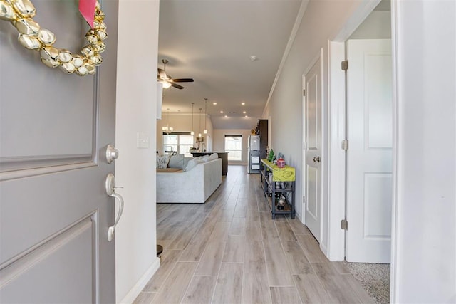 entrance foyer with light wood-type flooring, ceiling fan, and crown molding