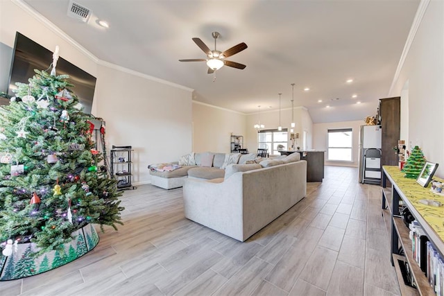 living room with ceiling fan, ornamental molding, and lofted ceiling