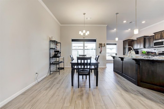 dining area with vaulted ceiling, ornamental molding, and an inviting chandelier