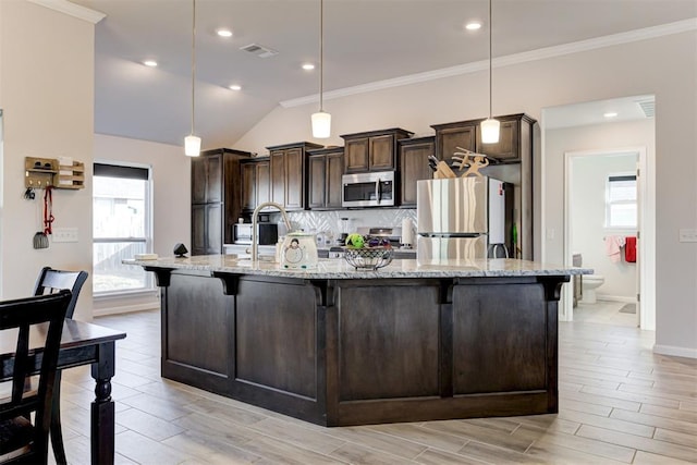 kitchen with pendant lighting, light stone countertops, a breakfast bar area, a large island, and stainless steel appliances