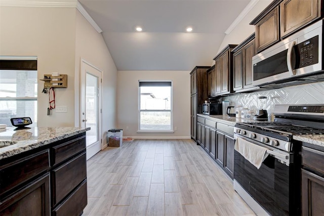 kitchen featuring backsplash, dark brown cabinetry, ornamental molding, stainless steel appliances, and light stone counters