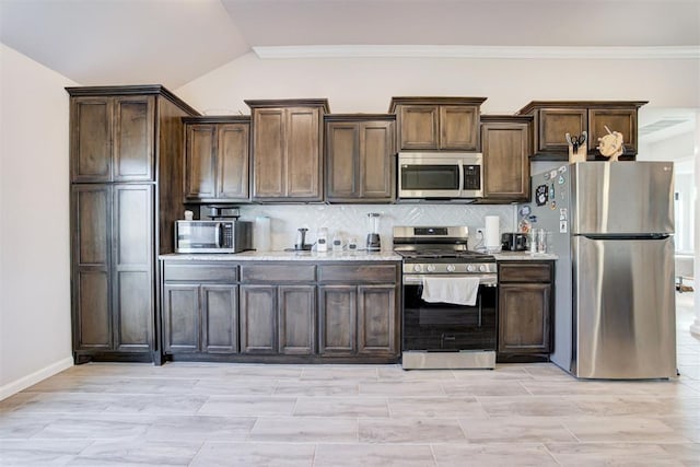 kitchen featuring dark brown cabinets, stainless steel appliances, and tasteful backsplash