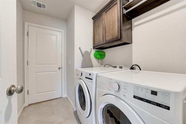 laundry room with cabinets, separate washer and dryer, and light tile patterned flooring