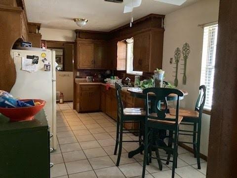 kitchen with white fridge, ceiling fan, and light tile patterned flooring