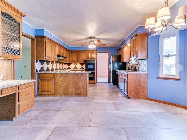 kitchen featuring ceiling fan with notable chandelier, light stone countertops, pendant lighting, black appliances, and tasteful backsplash